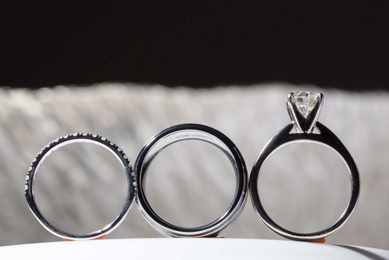 Silhouettes of two wedding bands and an engagement ring