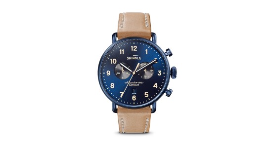 A blue Shinola watch with a number of complications and a tan leather strap