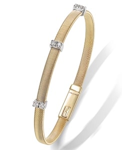 A three-diamond anniversary band features textured yellow gold