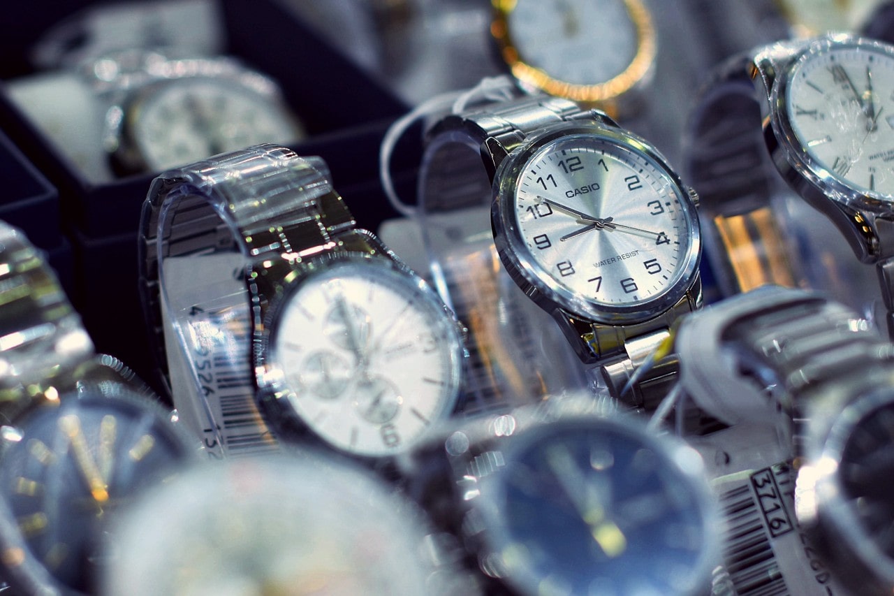 A collection of elegant wristwatches displayed in a store, featuring metallic bands and clear faces.