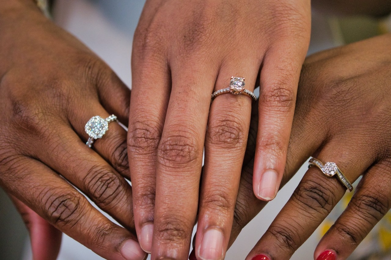 three women’s hands together, showing off their engagement rings