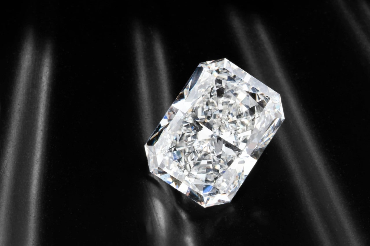 close up image of a radiant cut diamond on a reflective black surface