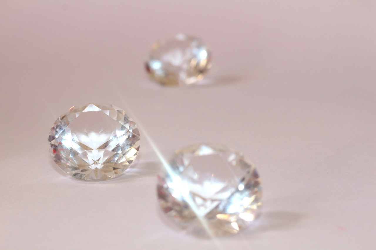 three round cut diamonds on a beige surface