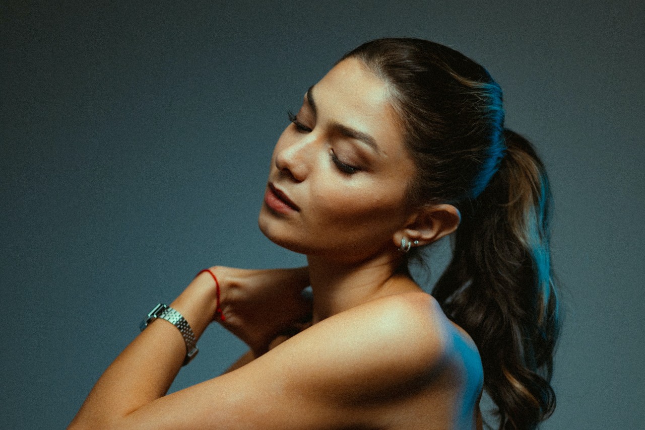 a woman looking away from the camera and wearing a silver watch