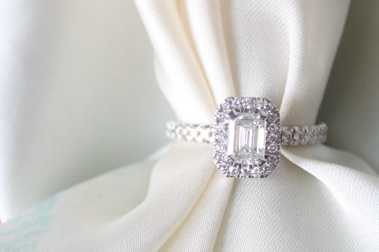 a diamond engagement ring wrapped around a white cloth