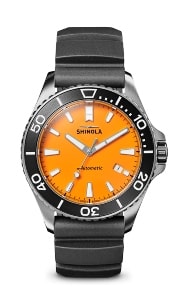 A Shinola Monster watch with an orange dial and black rubber strap.