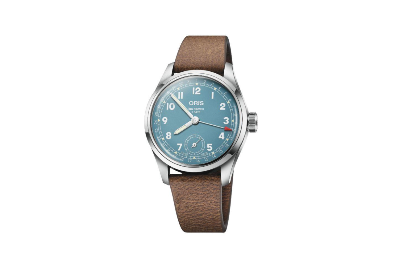 A stunning watch with a brown leather strap, a silver bezel, and a bright blue dial.