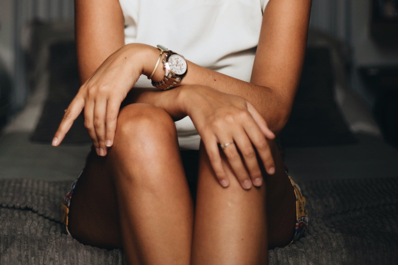 a lady wearing a luxury watch with her arms crossed